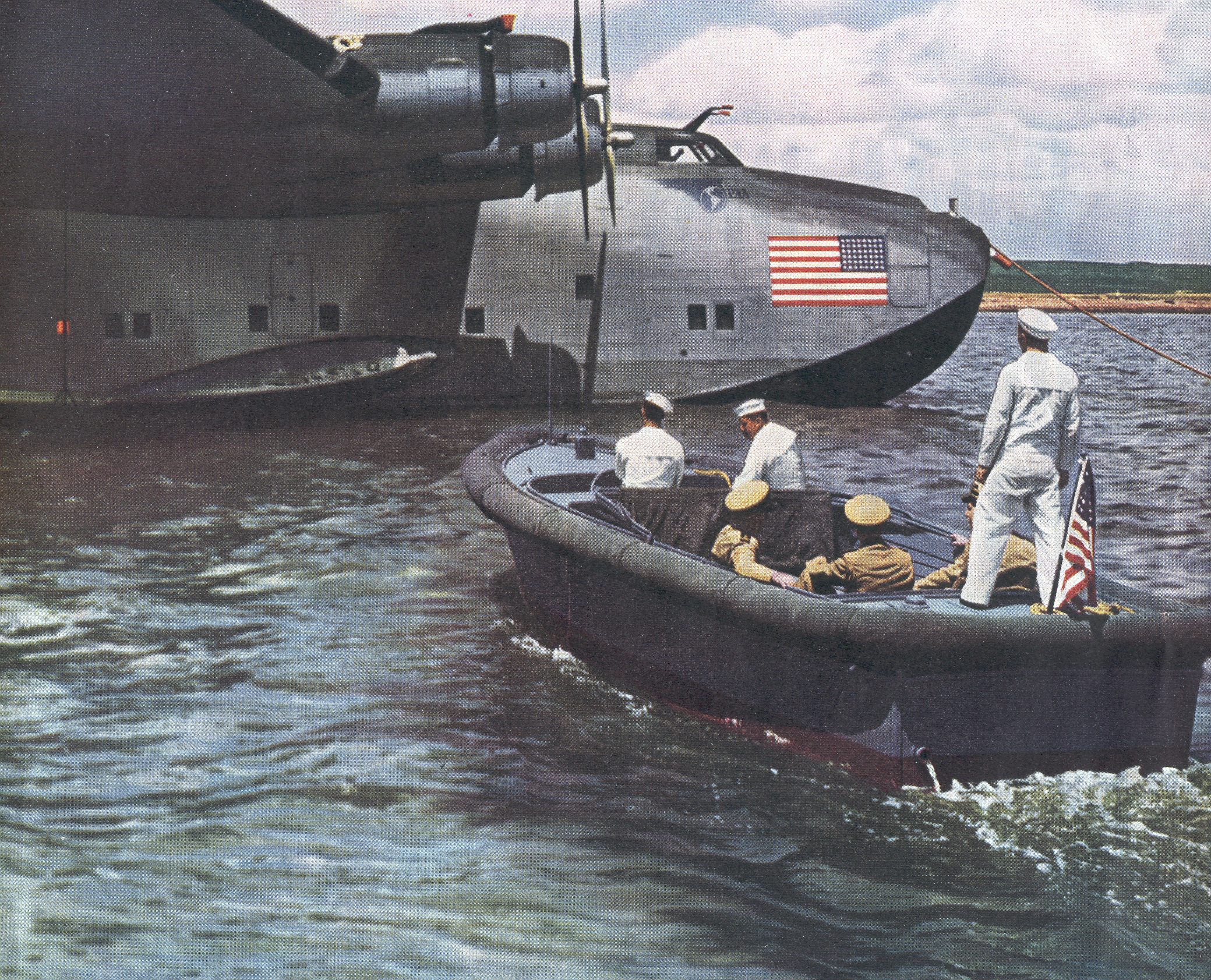 1940s  Navy Launch approaching a moored Boeing B314.  During World War II Pan Am's entire B314 fleet was operated on behalf of the United States Navy moving critical personell and supplies around the world.